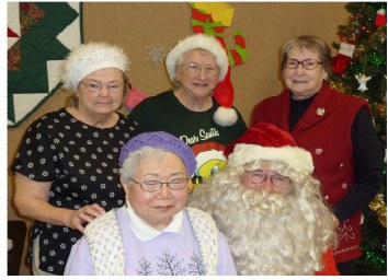 A group of members gathered around Santa